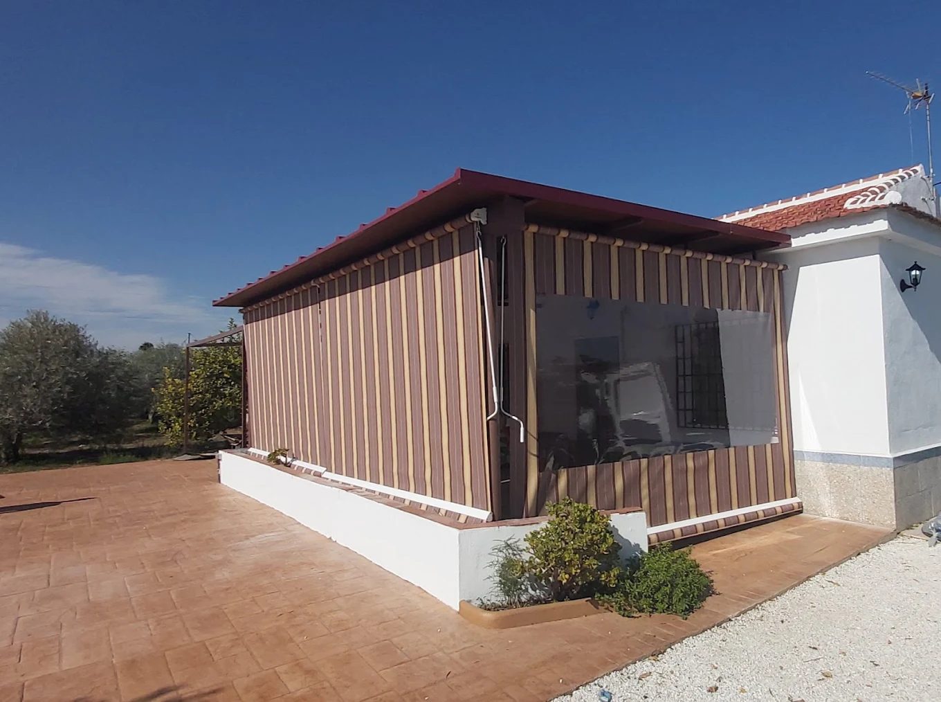 Toldo vertical de rayas con ventana de cristal en una casa de campo