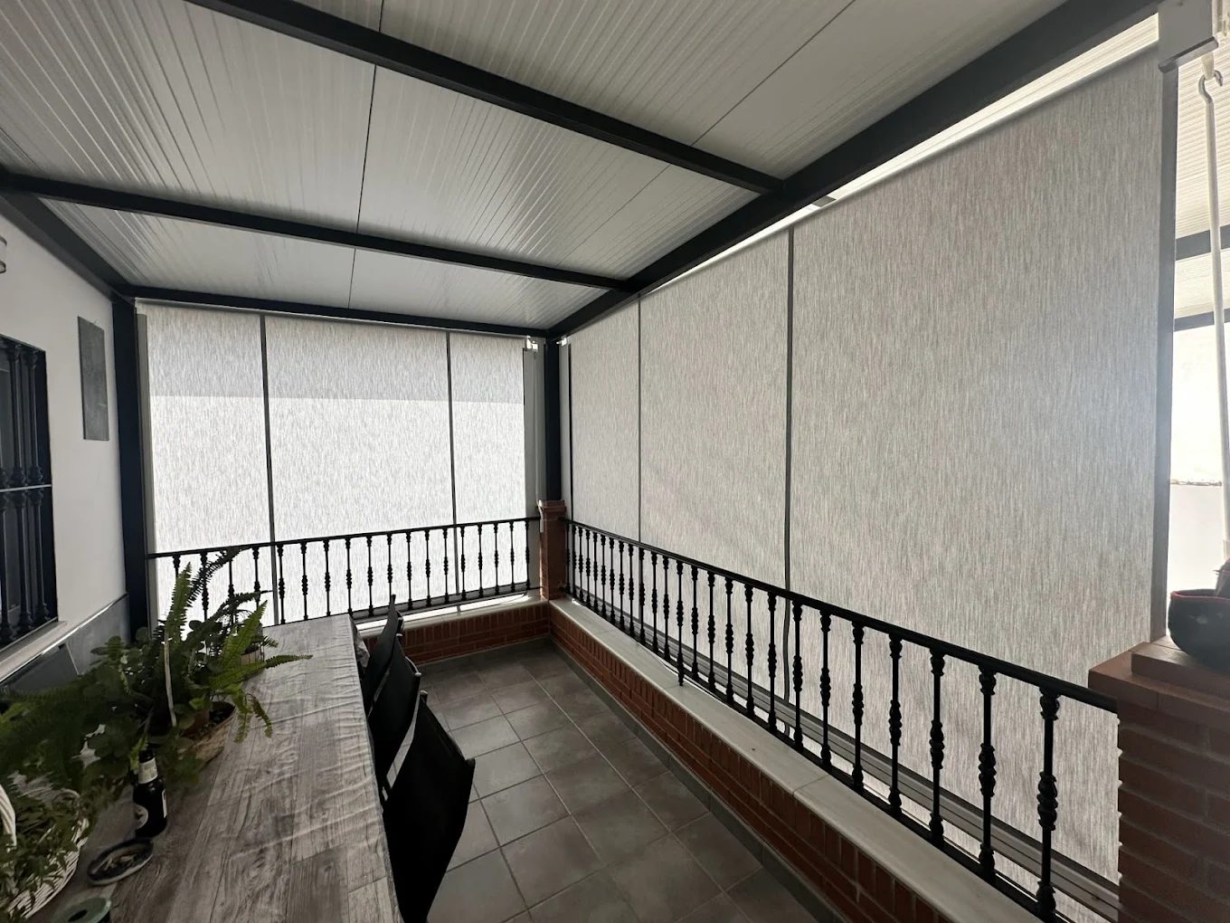Terraza cerrada con cortinas verticales y estores screen instalados